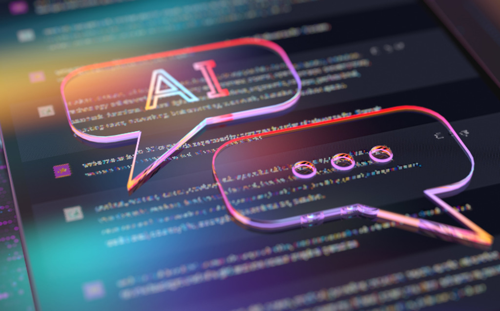 A digital image shows two translucent speech bubbles over a blurred screen of code. One bubble contains the letters AI and the other displays three dots, symbolizing conversation with artificial intelligence.