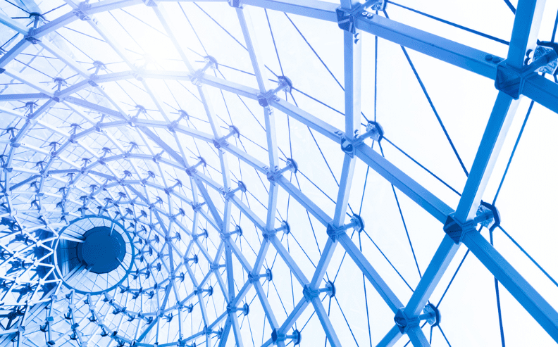 A close-up view of a modern glass and steel dome roof structure, featuring a repeating geometric pattern with sunlight streaming through the transparent panels.