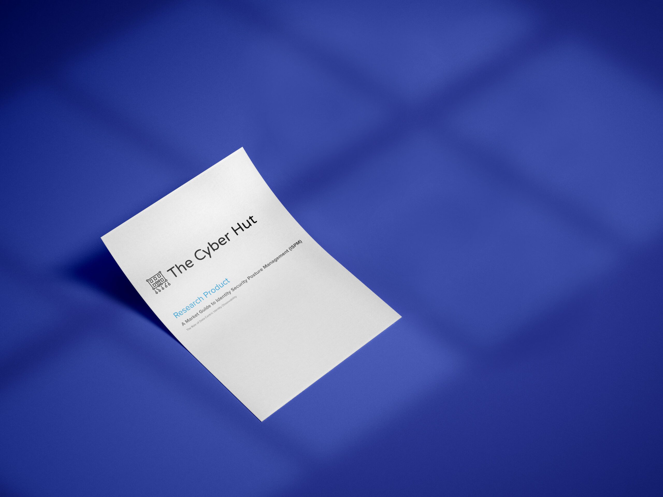 A single sheet of paper with The Cyber Hut logo and text lies at an angle on a blue surface, with soft shadow patterns visible in the background.