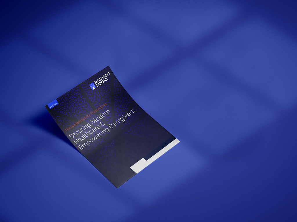 A booklet with a dark blue cover titled Securing Modern Healthcare & Empowering Caregivers by Radiant Logic rests on a blue surface under soft light and shadow.